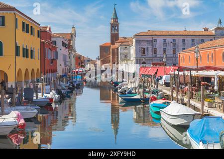 Les façades multicolores des bâtiments sur le canal Vena et en arrière-plan le clocher de l'église de San Giacomo Apostolo, Chioggia, municipalité de la ville métropolitaine de Venise, Vénétie, Italie Banque D'Images