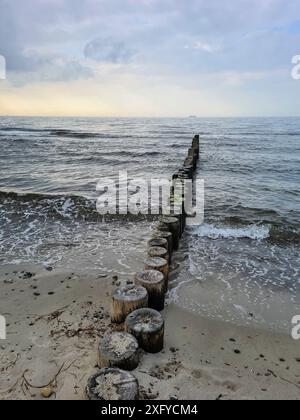 Ambiance nocturne sur la plage avec vue sur les groynes en bois de la mer Baltique au large de Markgrafenheide en direction de Warnemünde, Mecklenburg-Poméranie occidentale, Banque D'Images