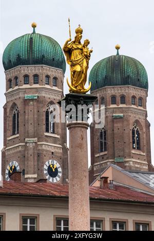 Devant les célèbres tours jumelles de la Frauenkirche se dresse la colonne Marienplatz à Munich Banque D'Images