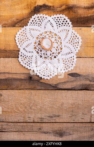 Dentelle doily avec bougie sur une base en bois Banque D'Images