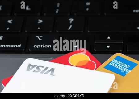 New York, États-Unis - 5 juillet 2024 : choisir une carte plastique pour payer en ligne avec un ordinateur portable Banque D'Images