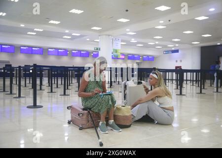 Cancun, Mexique. 5 juillet 2024. Les voyageurs attendent à l'intérieur de l'aéroport international de Cancun après l'arrivée de l'ouragan Beryl, à Cancun, dans l'état de Quintana Roo, au Mexique, le 5 juillet, 2024. dans les Caraïbes, plus d'un million de personnes ont été touchées par l'ouragan Beryl, ont déclaré vendredi les humanitaires des Nations Unies. Ouragan de catégorie 4 qui a fait au moins 11 morts à ce jour, Beryl a laissé lundi une traînée de destruction à Grenade et Saint-Vincent-et-les Grenadines, puis a touché la Jamaïque mercredi. L'ouragan affecte actuellement le Belize et le Mexique. Crédit : Alberto Valdez/Xinhua/Alamy Live News Banque D'Images