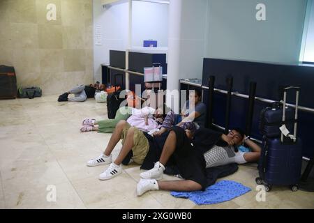 Cancun, Mexique. 5 juillet 2024. Les voyageurs attendent à l'intérieur de l'aéroport international de Cancun après l'arrivée de l'ouragan Beryl, à Cancun, dans l'état de Quintana Roo, au Mexique, le 5 juillet, 2024. dans les Caraïbes, plus d'un million de personnes ont été touchées par l'ouragan Beryl, ont déclaré vendredi les humanitaires des Nations Unies. Ouragan de catégorie 4 qui a fait au moins 11 morts à ce jour, Beryl a laissé lundi une traînée de destruction à Grenade et Saint-Vincent-et-les Grenadines, puis a touché la Jamaïque mercredi. L'ouragan affecte actuellement le Belize et le Mexique. Crédit : Alberto Valdez/Xinhua/Alamy Live News Banque D'Images