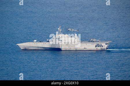 MER DE CHINE MÉRIDIONALE (28 juin 2024) - un hélicoptère NH-90 de la marine italienne survole le navire de combat littoral de la variante de l'indépendance USS Mobile (LCS 26) tandis qu'un hélicoptère MH-60R Seahawk embarqué atterrit sur le pont d'envol lors d'opérations bilatérales en mer de Chine méridionale, le 28 juin 2024. Mobile, qui fait partie du 7e escadron de destroyers, est en déploiement rotatif dans la zone d’opérations de la 7e flotte américaine pour améliorer l’interopérabilité avec les alliés et les partenaires et servir de force d’intervention prête à soutenir une région indo-pacifique libre et ouverte. (Photo de l'US Navy par le Lt. j.g. Akari Yarrell) Banque D'Images