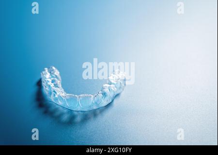 Gros plan aligners invisibles sur le fond bleu avec espace de copie. Appareils dentaires en plastique retenant les dents pour redresser les dents Banque D'Images