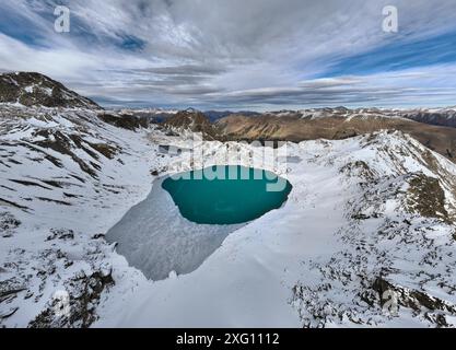 Vue aérienne du lac glaciaire de haute montagne et des sommets de montagne enneigés. Paysage d'un lac alpin par une journée ensoleillée Banque D'Images