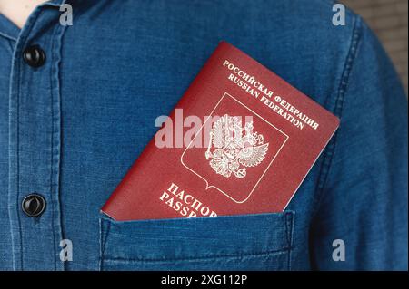 Passeport dans la poche d'une chemise en denim, gros plan. Concept voyage à l'étranger Banque D'Images