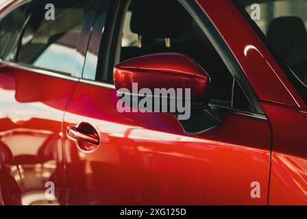 Voiture rouge dans la salle d'exposition de l'établissement concessionnaire, vente de voitures neuves, historique de l'industrie automobile Banque D'Images