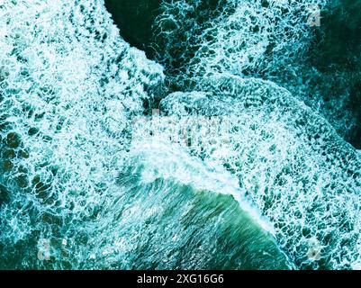 Vue aérienne turquoise tempête vagues océaniques avec de la mousse blanche dans l'océan, eau de mer avec des éclaboussures et de la mousse, fond de vagues vue de dessus, arrière-plan naturel Banque D'Images