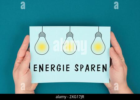 Save Energy est debout en langue allemande sur le papier, les ampoules, l'augmentation des coûts d'électricité et de gaz, les règlements pour l'hiver, les sanctions Banque D'Images