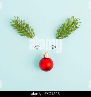 Visage d'un renne avec un nez de boule rouge, des bois de sapin et des yeux amicaux, carte de vœux de joyeux noël Banque D'Images