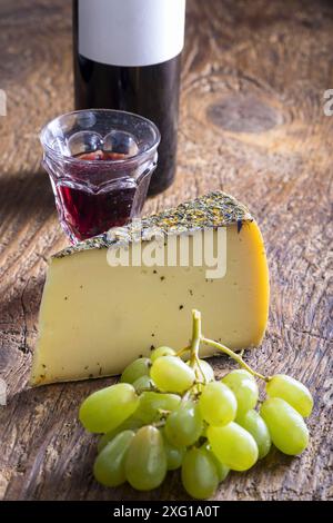 Fromage de montagne avec raisins sur bois Banque D'Images