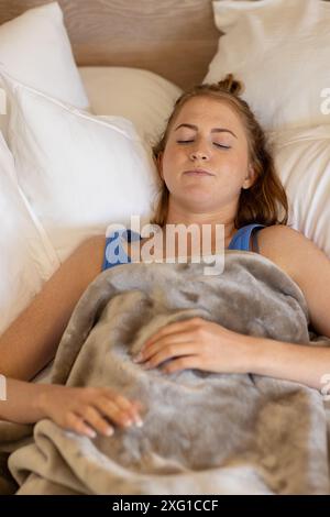 Dormir paisiblement sous une couverture douillette, femme se reposant dans le lit Banque D'Images