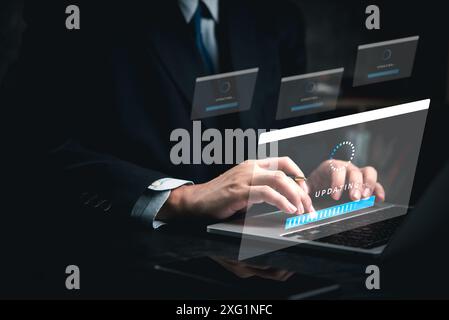 Un homme tape sur un ordinateur portable avec un écran bleu qui dit mise à jour. L'homme porte un costume et une cravate, et l'ordinateur portable est sur un bureau. Notion d'urgence Banque D'Images
