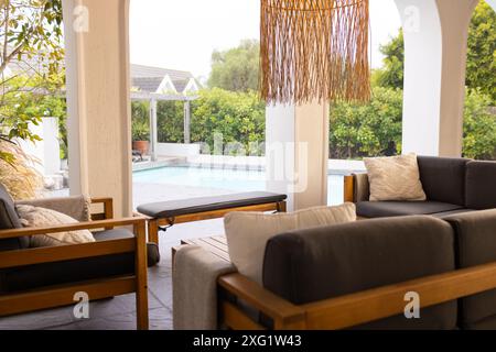 Patio extérieur avec mobilier moderne donnant sur la piscine dans la cour arrière, espace photocopie Banque D'Images