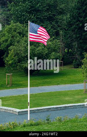 Drapeau américain sur poteau brandissant au vent devant les arbres au Mardasson Mermorial à Bastogne, Belguim Banque D'Images