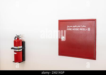 Le tuyau d'incendie est emballé dans une boîte d'urgence rouge sur le mur, bobine de tuyau d'incendie Banque D'Images