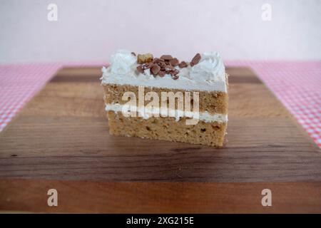 Tranche de gâteau aux carottes avec glaçage sur planche de bois Banque D'Images