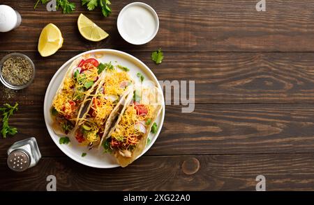 Tacos avec des légumes et de la viande de poulet sur plaque blanche sur fond en bois avec espace libre. Vue de dessus, pose à plat Banque D'Images