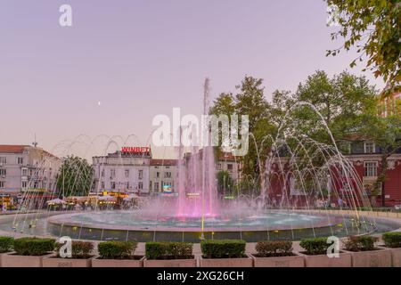 Varna, Bulgarie - 22 septembre 2023 : coucher de soleil sur la place de l'indépendance et la fontaine, avec les habitants et les visiteurs, Varna, Bulgarie Banque D'Images