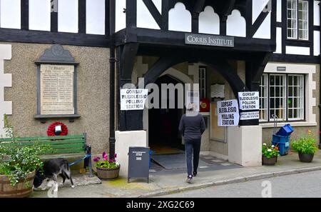 Bureau de vote dans un village rural dans le sud de Gwynedd, montrant Corris Institute avec des signes de vote femelle marchant à la porte, également chien attaché au siège. Banque D'Images