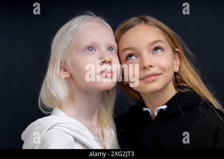 deux belles filles rêvant de regarder vers le haut fond noir isolé. les amis inventent le plan, la démission Banque D'Images