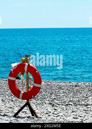 Bouée de sauvetage au bord de la mer. EQUIPEMENT de sécurité de plage. Positionné au bord de l'eau pour les urgences et les secours. Banque D'Images