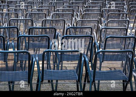 vue de derrière des chaises en métal vert disposées symétriquement dans un parc Banque D'Images