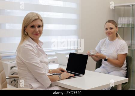 Client avec tasse de café dans la clinique médicale Banque D'Images