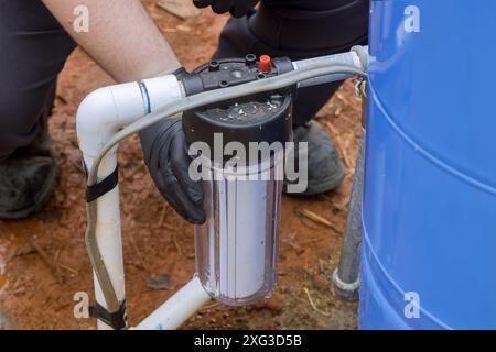 Le préposé à l'entretien remplace le filtre à l'installation de traitement de l'eau domestique Banque D'Images