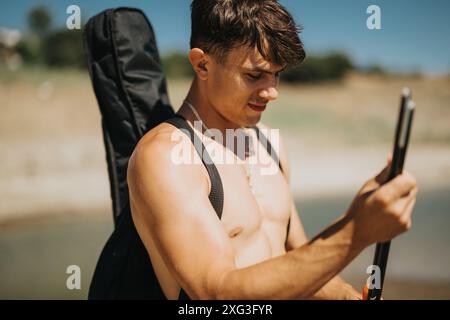 Jeune homme avec sac à dos jouissant d'une activité de plein air sur une journée ensoleillée Banque D'Images