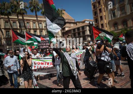 Malaga, Espagne. 06 juillet 2024. Des manifestants sont vus avec des pancartes et des drapeaux palestiniens alors qu'ils participent à une manifestation de solidarité avec le peuple palestinien. Sous le slogan "contre le génocide et l'occupation sioniste", des dizaines de personnes exigent la fin du commerce des armes et des relations commerciales avec Israël, dans le contexte des conflits en cours entre Israël et le Hamas. Crédit : SOPA images Limited/Alamy Live News Banque D'Images