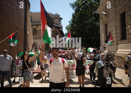 Malaga, Espagne. 06 juillet 2024. On voit un homme portant un drapeau palestinien alors qu'il participe à une manifestation de solidarité avec le peuple palestinien. Sous le slogan "contre le génocide et l'occupation sioniste", des dizaines de personnes exigent la fin du commerce des armes et des relations commerciales avec Israël, dans le contexte des conflits en cours entre Israël et le Hamas. Crédit : SOPA images Limited/Alamy Live News Banque D'Images