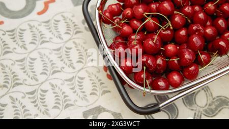 Nature nutrition saine fruits d'été cerises fraîches en passoire sur tuile rétro backgroun Banque D'Images