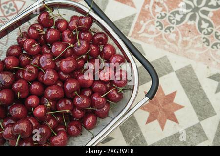 Nature nutrition saine fruits d'été cerises fraîches en passoire sur tuile rétro backgroun Banque D'Images