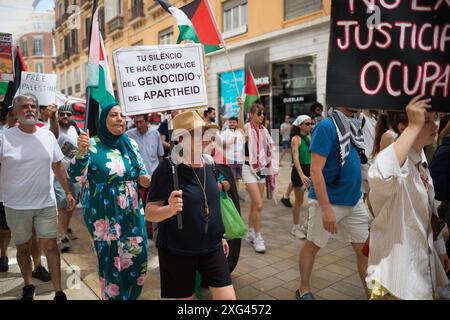 Malaga, Espagne. 06 juillet 2024. Une manifestante est vue tenant une pancarte dénonçant le génocide en Palestine alors qu'elle participe à une manifestation de solidarité avec le peuple palestinien. Sous le slogan "contre le génocide et l'occupation sioniste", des dizaines de personnes exigent la fin du commerce des armes et des relations commerciales avec Israël, dans le contexte des conflits en cours entre Israël et le Hamas. (Photo de Jesus Merida/SOPA images/SIPA USA) crédit : SIPA USA/Alamy Live News Banque D'Images