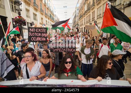 Malaga, Espagne. 06 juillet 2024. Des manifestants sont vus avec des pancartes et des drapeaux palestiniens alors qu'ils participent à une manifestation de solidarité avec le peuple palestinien. Sous le slogan "contre le génocide et l'occupation sioniste", des dizaines de personnes exigent la fin du commerce des armes et des relations commerciales avec Israël, dans le contexte des conflits en cours entre Israël et le Hamas. (Photo de Jesus Merida/SOPA images/SIPA USA) crédit : SIPA USA/Alamy Live News Banque D'Images