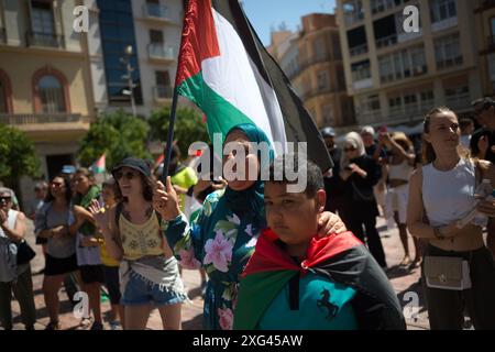 Malaga, Espagne. 06 juillet 2024. Une femme portant un drapeau palestinien est vue accompagnée d'un enfant alors qu'elle participe à une manifestation de solidarité avec le peuple palestinien. Sous le slogan "contre le génocide et l'occupation sioniste", des dizaines de personnes exigent la fin du commerce des armes et des relations commerciales avec Israël, dans le contexte des conflits en cours entre Israël et le Hamas. (Photo de Jesus Merida/SOPA images/SIPA USA) crédit : SIPA USA/Alamy Live News Banque D'Images