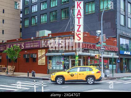 New York City, États-Unis - 27 mai 2024, Un taxi jaune s'arrête devant le célèbre Katz Deli de Manhattan Banque D'Images