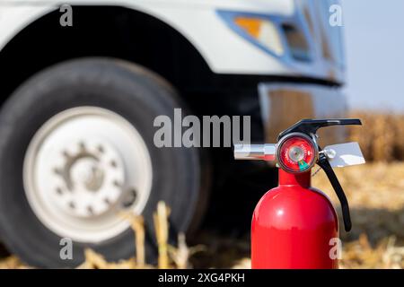 Extincteur et camion à grain dans le champ de maïs pendant la récolte. Concept de sécurité agricole, de sécurité incendie et de prévention des accidents. Banque D'Images