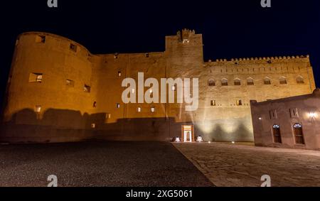 Jabreen citadelle murs de pierre de la forteresse et tour de bastion ronde dans l'illumination nocturne, Bahla, sultanat Oman Banque D'Images