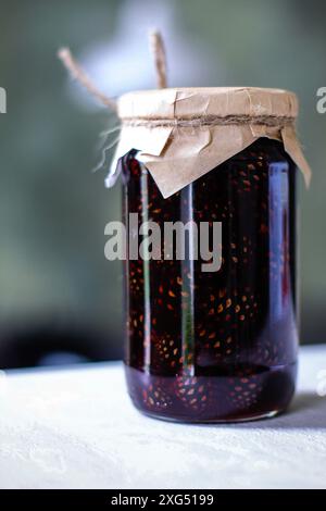 Pot de confiture de cône de pin savoureuse sur fond clair, gros plan Banque D'Images