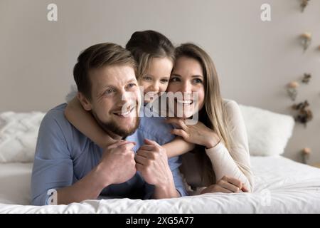 Toute la famille reposant sur un matelas confortable dans une chambre confortable Banque D'Images