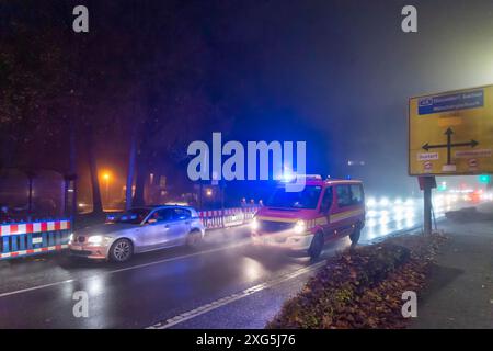 Ambulance des pompiers dans la circulation routière la nuit Banque D'Images