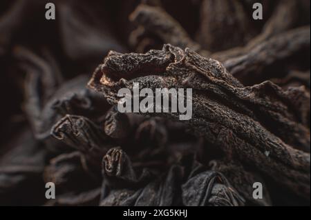 Extreme macro Black Loose Leaf Tea comme fond. Texture des feuilles de thé noir sèches dans une faible profondeur de champ. Fond sombre. mode macro. noir Banque D'Images