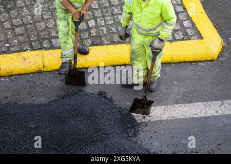 Les travailleurs prennent une pause pendant les réparations de la route asphaltée.Pavage en asphalte.Vue grand angle Banque D'Images