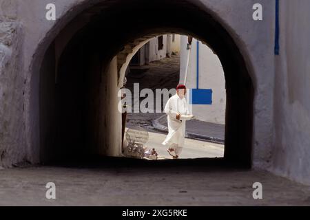 La Tunisie, Sidi Bou Said. L'homme en costume traditionnel tunisien transportant un bac d'oeufs. Banque D'Images