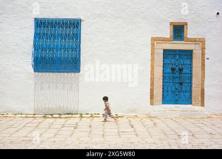 La Tunisie, Sidi Bou Said. Petit garçon marche dans la rue. Banque D'Images