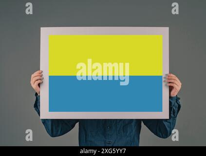 Le jeune homme porte un signe avec le drapeau ukrainain, l'idendité nationale, la crise de guerre entre l'Ukraine et la Russie, la question politique, bleu et jaune de couleur Banque D'Images