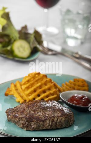 Steak grillé avec grilles de pommes de terre fraîches Banque D'Images